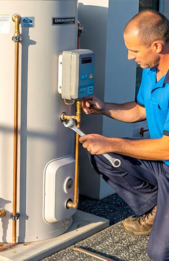 Plumber Tightening Water Heater Pipe